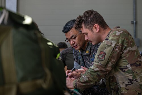A U.S. Air Force Airman and ROK Air Force Airman inspecting cargo