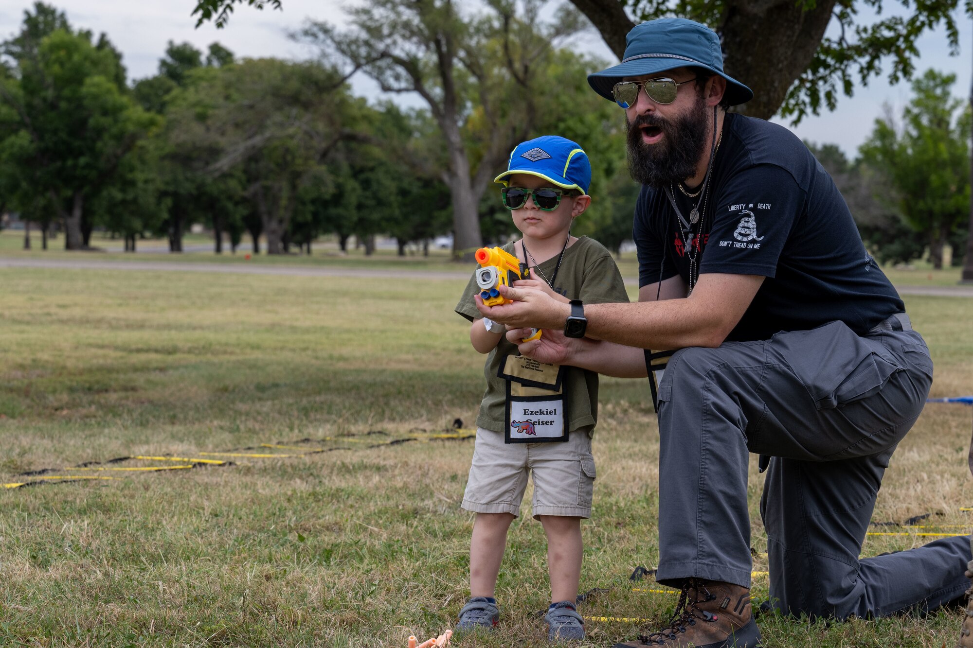 Family Mobility Line attendants shoot a toy gun on Sept. 21, at McConnell Air Force Base, Kansas. The event was for service members’ families to experience and understand the deployment process. (U.S. Air Force photo by Airman 1st Class Paula Arce)