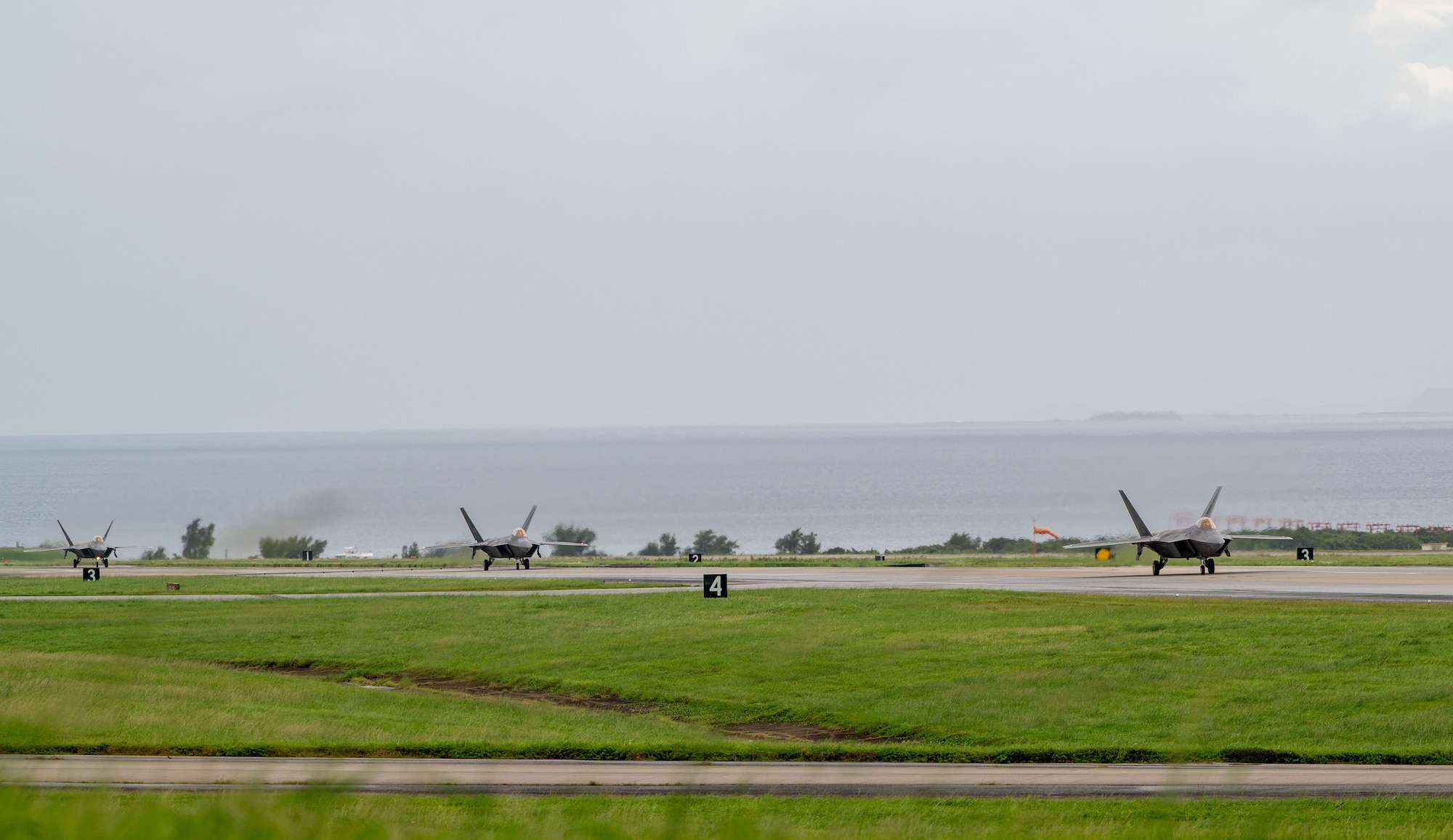 U.S. Air Force F-22A Raptors, assigned to the 1st Fighter Wing, Joint Base Langley-Eustis, Virginia, and the 19th Fighter Squadron,  Hawaii, taxi down the runway during exercise Southern Beach at Kadena Air Base, Japan, Sept. 19, 2024. Kadena routinely conducts exercises critical to deterring aggression, maintaining readiness to protect the interests of the U.S. and its allies. (U.S. Air Force photo by Senior Airman Luis E. Rios Calderon)