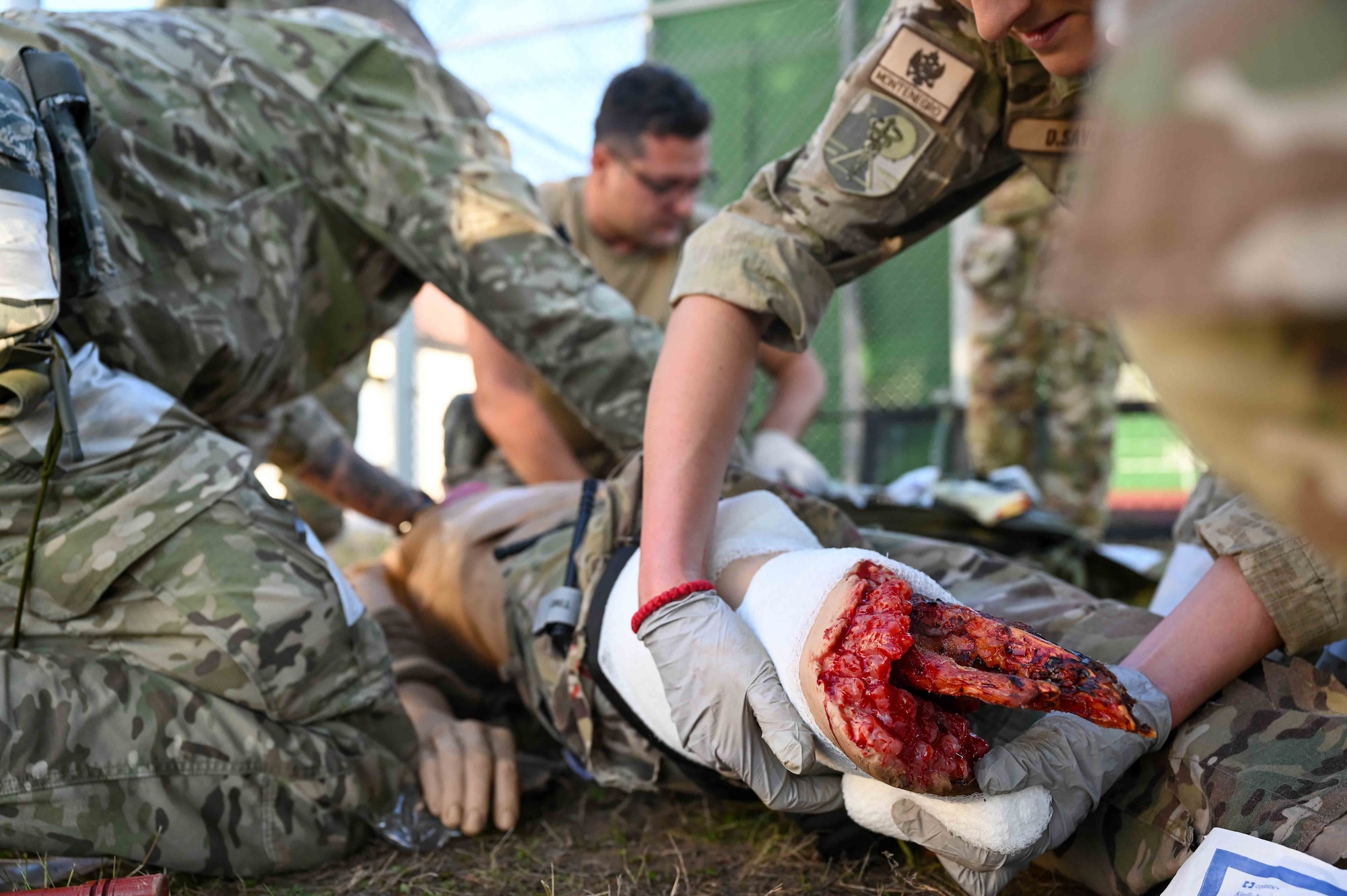 Service members from Montenegro, Bosnia and Herzegovina wrap a wound and check for other possible wounds on a dummy at Ramstein Air Base, Germany, Sept. 19, 2024.