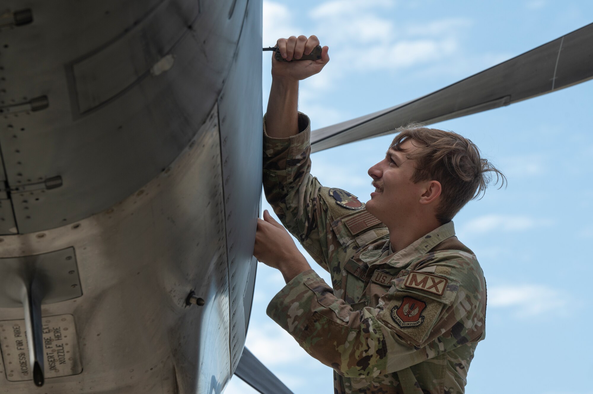 A man performs maintenance on a plane