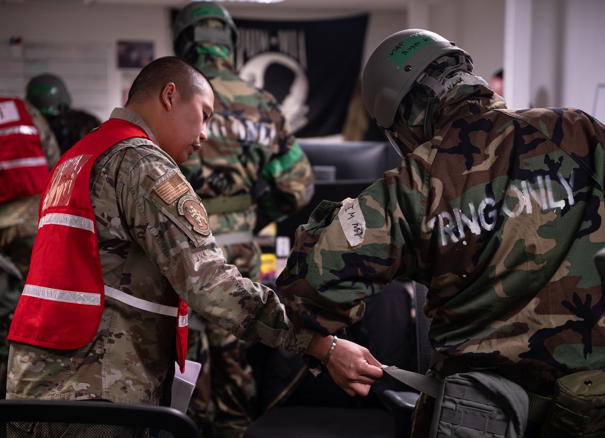 U.S. Air Force Tech. Sgt. Ryan Caballero, left, 100th Logistics Readiness Squadron Vehicle Management vehicle maintenance superintendent, monitors Airmen for correct and timely wear of their mission-oriented protective posture gear at Royal Air Force Mildenhall, England, Sept. 20, 2024.