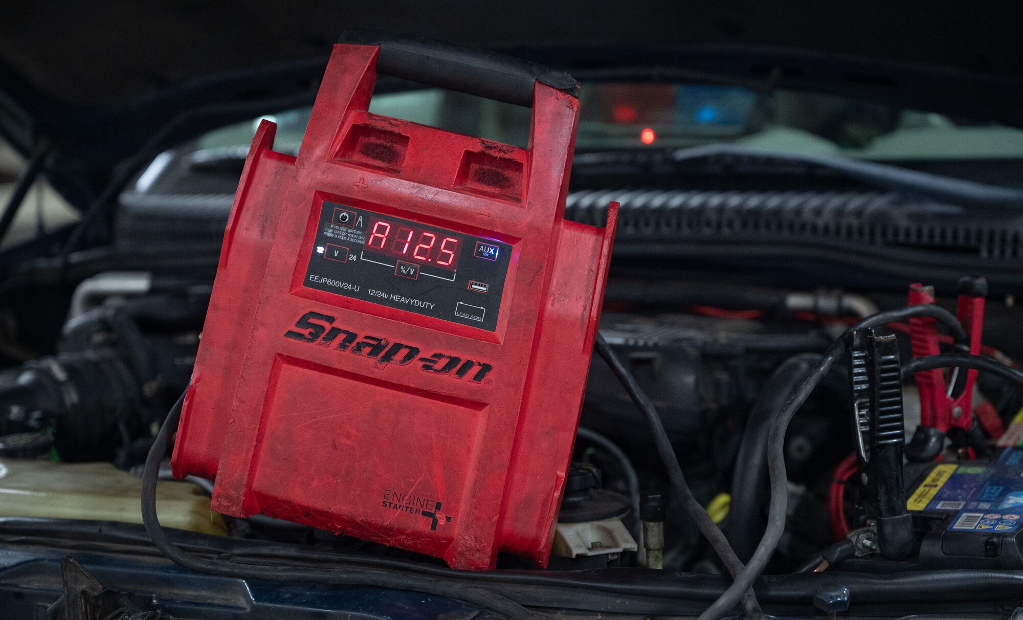 An engine starter jump pack is applied to a vehicle battery and displays the internal battery voltage during the base readiness exercise at Royal Air Force Mildenhall, England, Sept. 20, 2024.