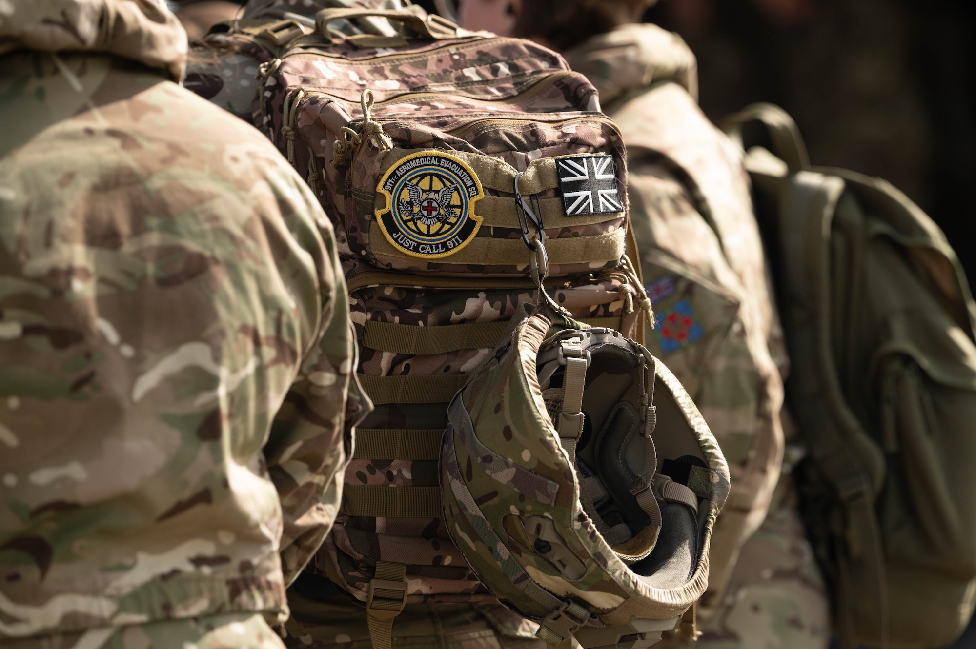 a 911th Aeromedical Evacuation Squadron patch and Royal Auxiliary Air Force 612 Squadron patch are velcroed to the back of a medical member's backpack
