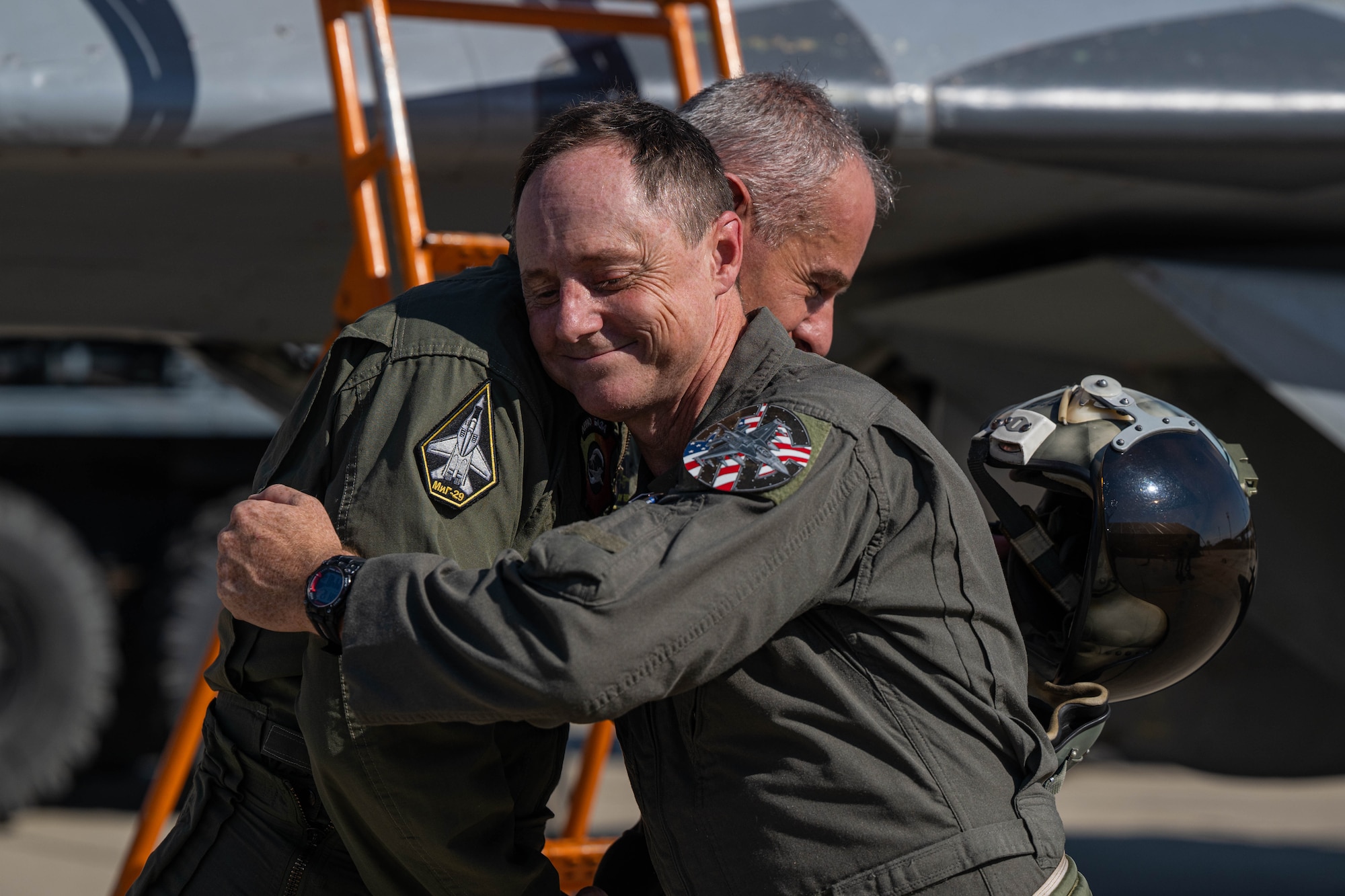 two military members hug