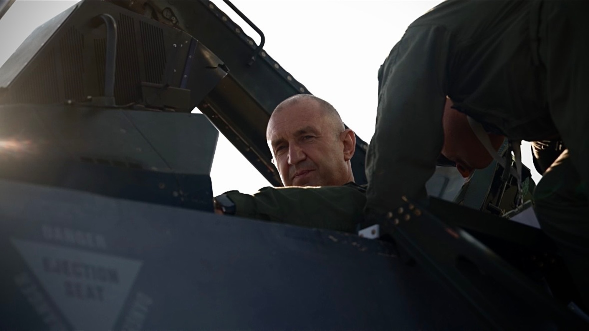 someone helps a military member into an F-16