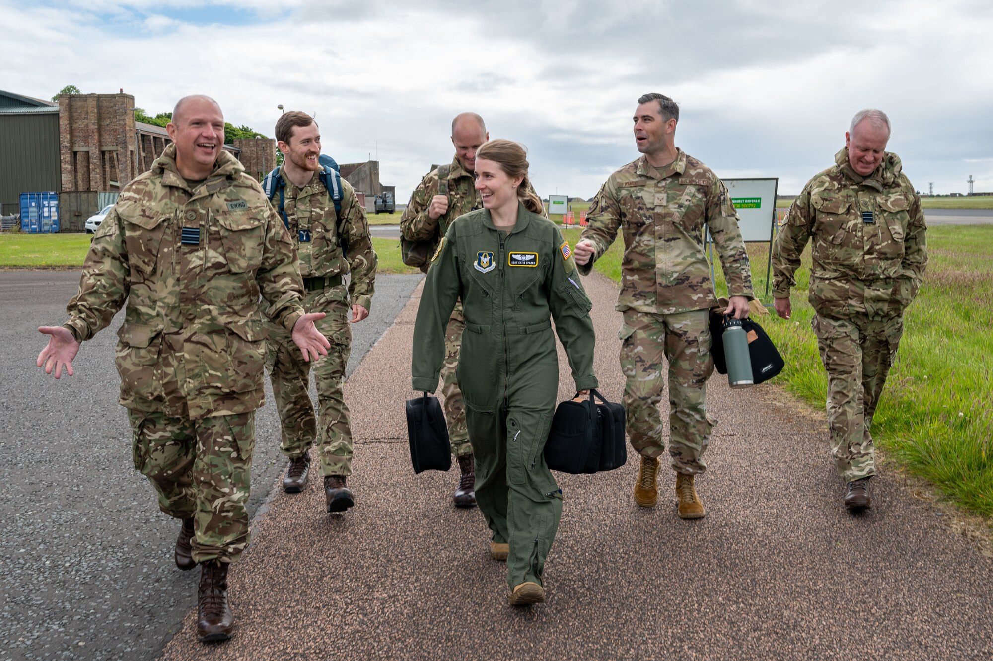 Airmen from the 911th Aeromedical Evacuation Squadron and Royal Auxiliary Air Force 612 Squadron walk toward camera in conversation
