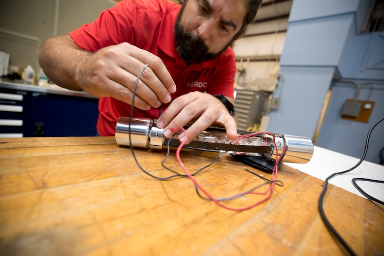 Jose Mattei-Sosa, a chemical engineer in the Environmental Laboratory, attaches the UV LED brackets to the quartz tube that contain the titanium dioxide/PLA static mixers for testing, July 17.