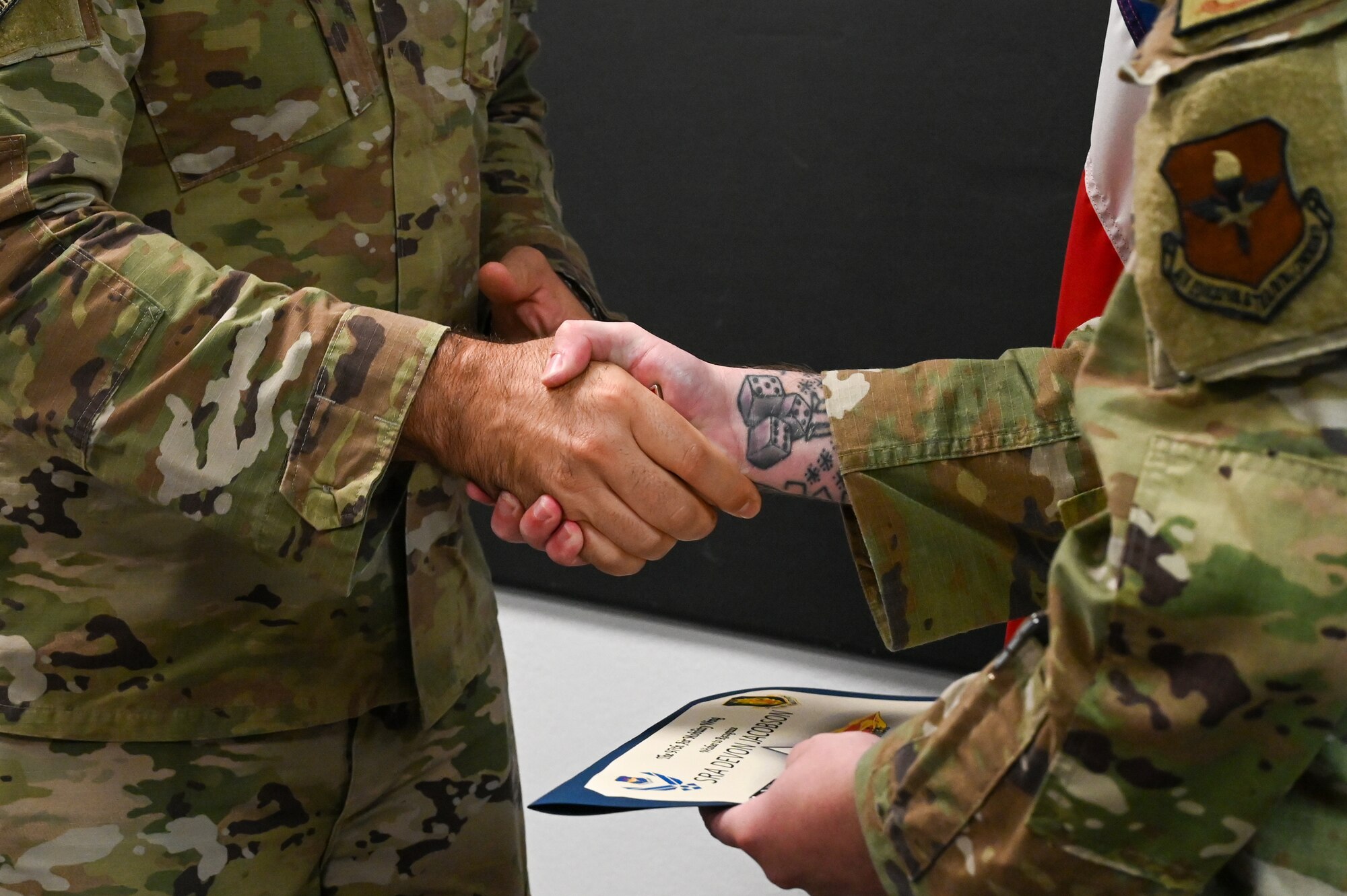 U.S. Air Force Chief Master Sgt. Justin Brundage, 97th Air Mobility Wing command chief, awards a coin to Senior Airman Devon Jacobson, 97th Security Forces Squadron patrolman, at
Altus Air Force Base, Oklahoma, September 16, 2024. Jacobson managed eight patrols, monitored 56 camera systems and 31 alarmed buildings to ensure the safety of 11,200 people. (U.S. Air Force photo by Senior Airman Kari Degraffenreed)