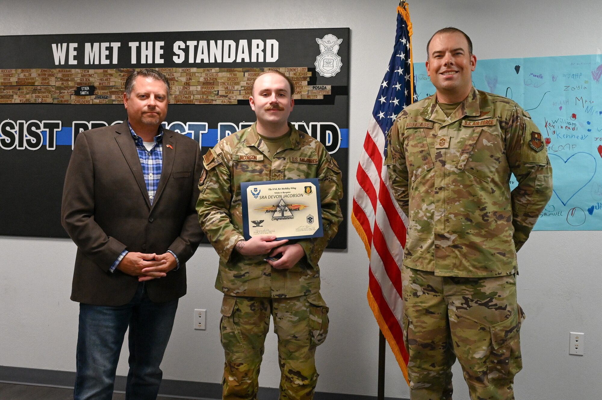 U.S. Air Force Senior Airman Devon Jacobson, 97th Security Forces Squadron patrolman, poses with Chief Master Sgt. Justin Brundage, 97th Air Mobility Wing command chief, and Justin Jacobson, his father, at Altus Air Force Base, Oklahoma, September 16, 2024. Jacobson was inspired to join the Air Force because of his father’s 20 years of service in the U.S. Marine Corps. (U.S. Air Force photo by Senior Airman Kari Degraffenreed)