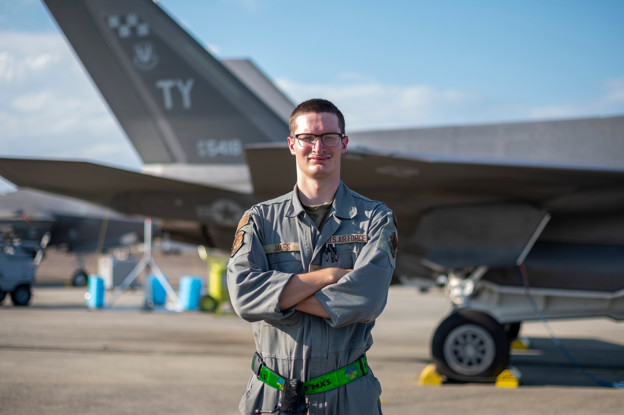 man poses next to plane