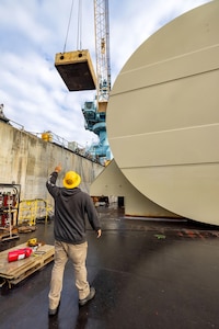 A team of riggers from Code 740, Riggers, lift pieces of steel from under a Reactor Compartment Disposal package, Sept. 12, 2024, so welders can remove the pad eyes from the structure before shipping at Puget Sound Naval Shipyard & Intermediate Maintenance Facility in Bremerton, Washington. 
(U.S. Navy photo by Wendy Hallmark)