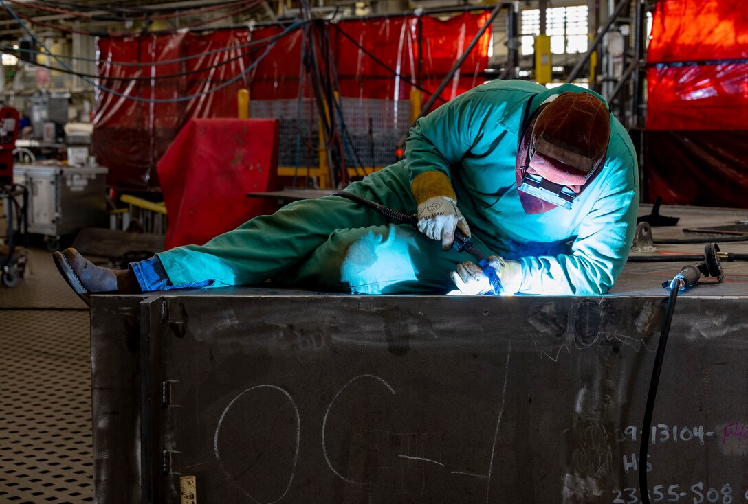 Parker McKane, welder, Shop 26, Welders, works on a section of a Reactor Compartment Disposal package in Building 460, Sept. 11, 2024, at Puget Sound Naval Shipyard & Intermediate Maintenance Facility in Bremerton, Washington. Shop 26 recently completed its fourth RCD package with zero rejectable conditions on all volumetrically inspected weld joints. Volumetrically inspected joints are critical welds used on all submarines and aircraft carriers. The welds are inspected using ultrasound or radiographic equipment. (U.S. Navy photo by Wendy Hallmark)