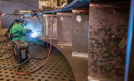 David Heiland, welder, Shop 26, Welders, works on a section of a Reactor Compartment Disposal package support structure on the "Big Slab" in Building 460 at Puget Sound Naval Shipyard & Intermediate Maintenance Facility in Bremerton, Washington. (U.S. Navy photos by Wendy Hallmark)