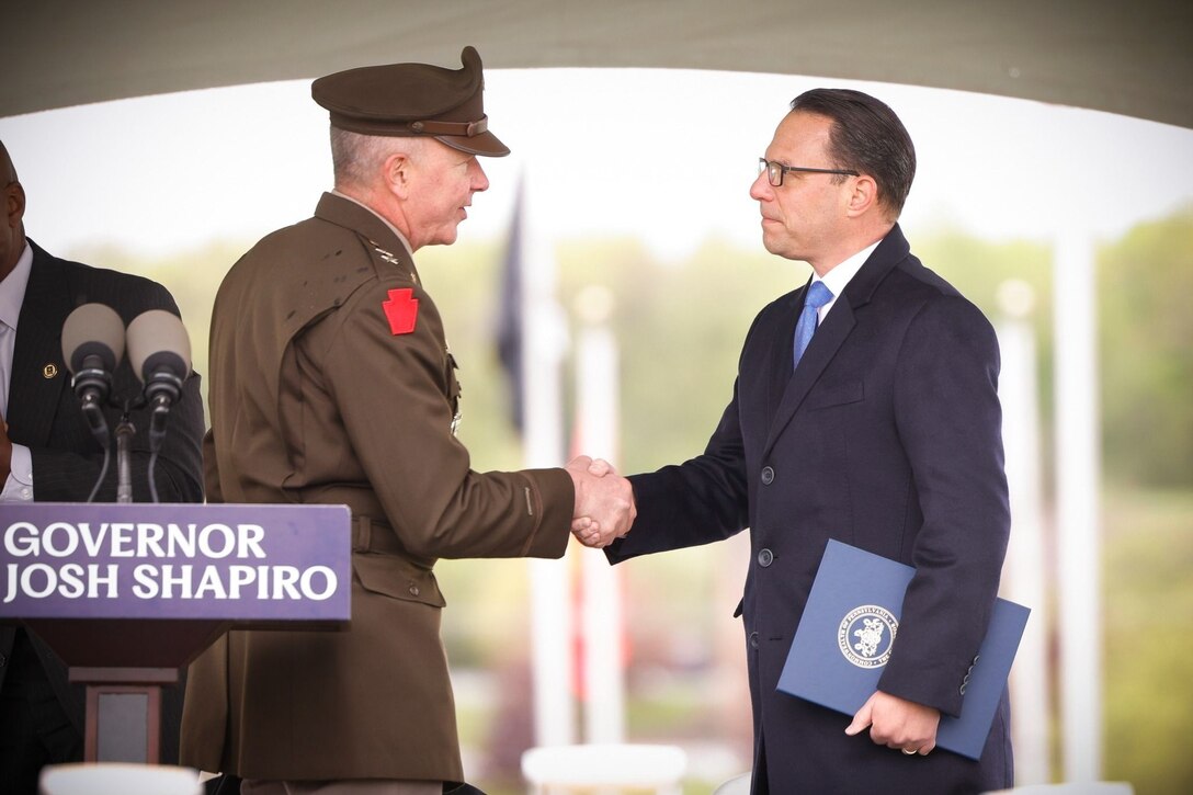 Pennsylvania Adjutant General Maj. Gen. Mark Schindler, left, shakes hands with Pennsylvania Gov. Mark Shapiro. Schindler announced his retirement Sept. 23, 2024, after 37 years of military service.