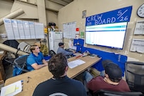 Seth Zwiefelhofer (left), digital transformation process manager, Code 900DX, Digital Transformation, goes over the new electronic crew board program with members of Shop 26, Welders, Sept. 19, 2024, in Building 1106 at Puget Sound Naval Shipyard & Intermediate Maintenance Facility in Bremerton, Washington. (U.S Navy photo by Jeb Fach)