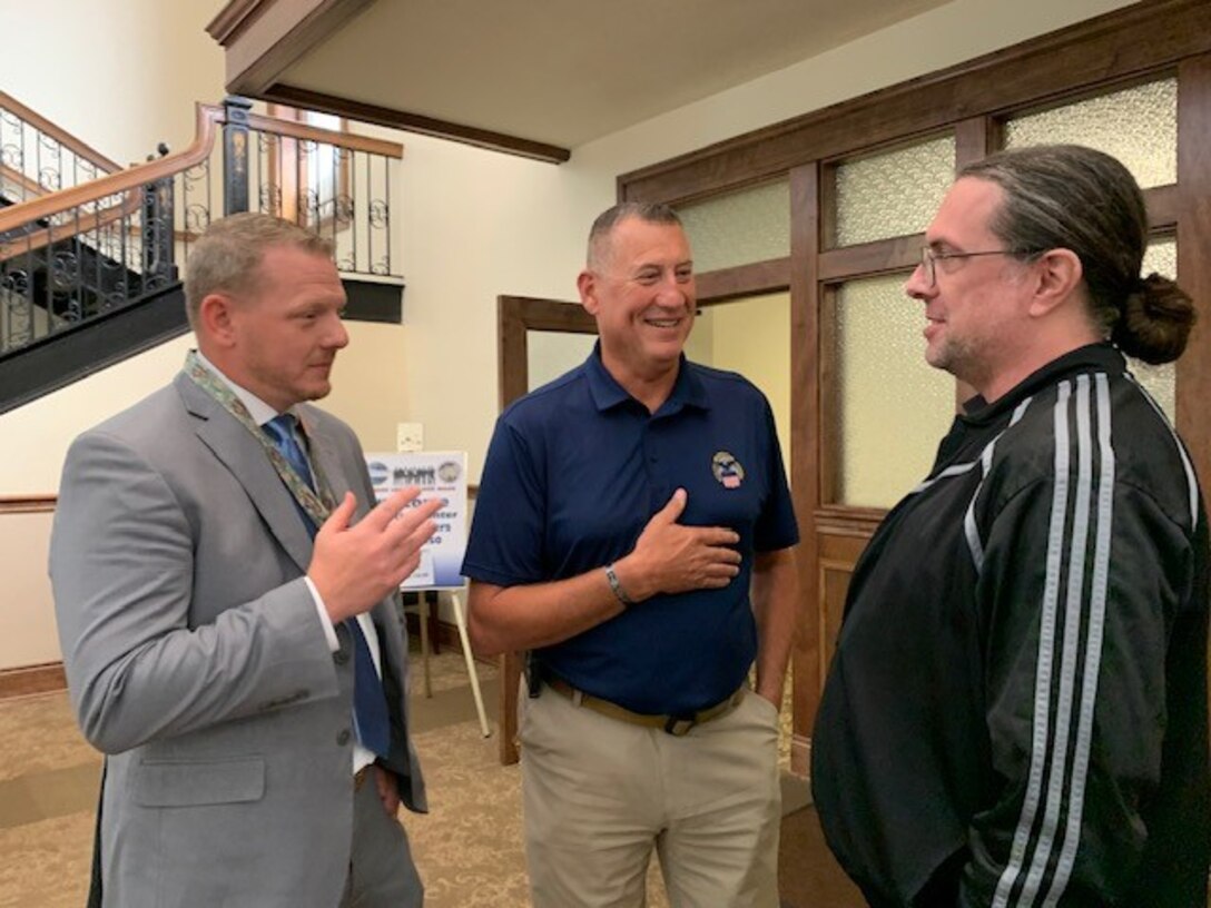 Benjamin  Burton and Albert Whatmough from Defense Logistics Agency Land and Maritime discuss cataloging changes with Army representative Will Roach