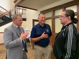 Benjamin  Burton and Albert Whatmough from Defense Logistics Agency Land and Maritime discuss cataloging changes with Army representative Will Roach