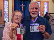 Mary Lighthill and Steven Lighthill, Wheatland Union High School alumni, pose with pictures from their high school yearbook at the Foothills Chapel on Beale Air Force Base, California, Sept. 20, 2024.