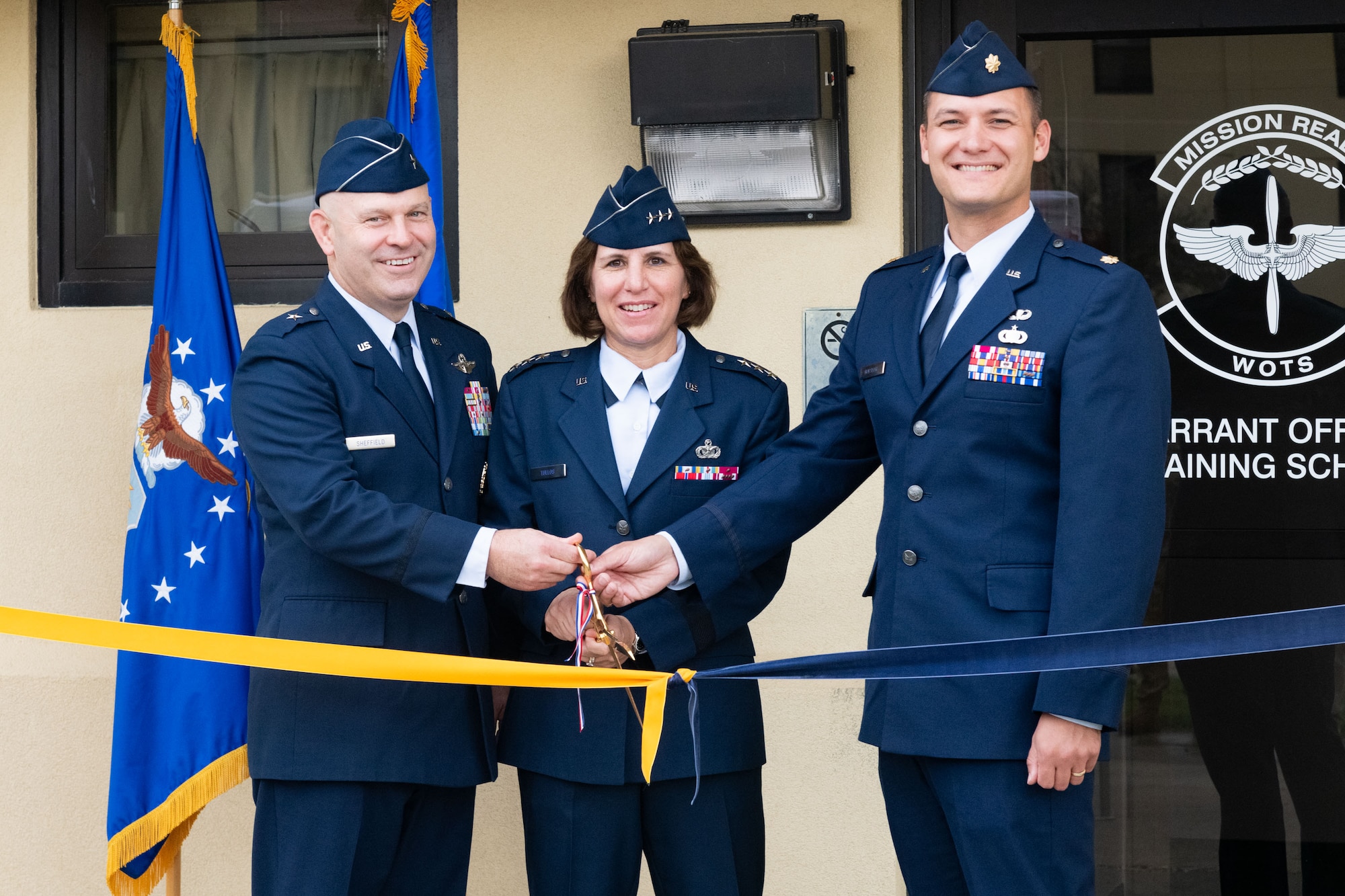 U.S. Air Force Brig. Gen. Joseph Sheffield, Commander of the Jeanne M. Holm Center, U.S. Air Force Lt. Gen. Andrea Tullos, Commander and President of Air University, and U.S. Air Force Maj. Nathaniel Roesler, Warrant Officer Training School commandant, cut the ceremonial ribbon at the WOTS ribbon cutting ceremony at Maxwell Air Force Base, Alabama, Sept. 25, 2024. (U.S. Air Force photo by  Darius Hutton)