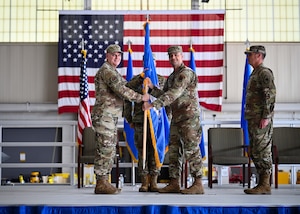 U.S. Air Force Lt. Gen. Michael Koscheski, deputy commander of Air Combat Command, passes the guidon to U.S. Air Force Col. William Watkins, 22nd Air Task Force commander, during an assumption of command ceremony