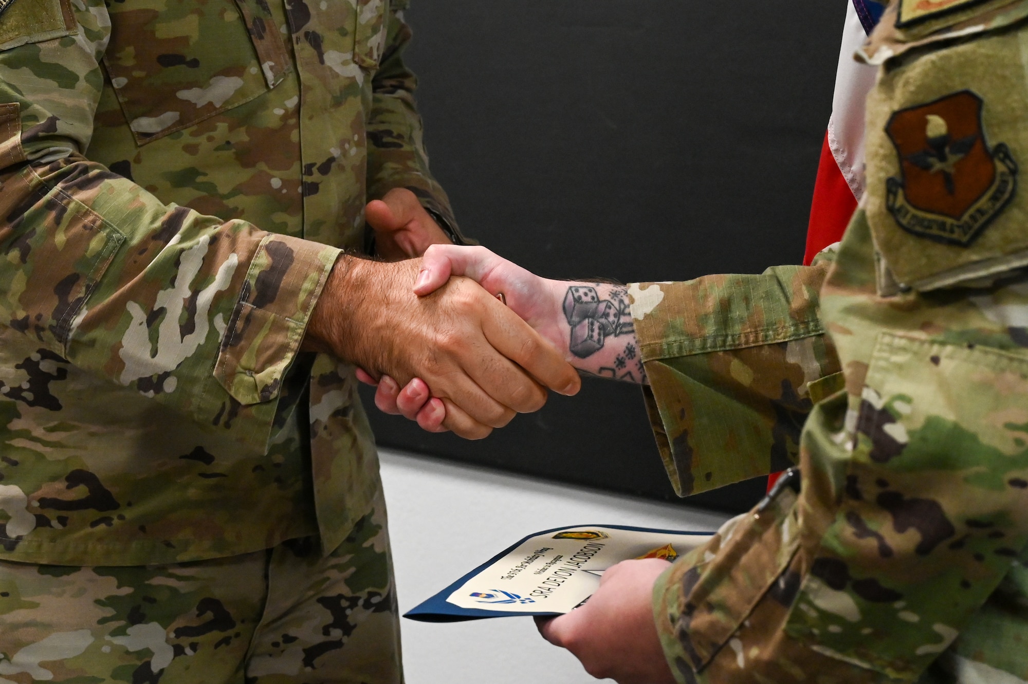 U.S. Air Force Chief Master Sgt. Justin Brundage, 97th Air Mobility Wing command chief, awards a coin to Senior Airman Devon Jacobson, 97th Security Forces Squadron patrolman, at
Altus Air Force Base, Oklahoma, September 16, 2024. Jacobson managed eight patrols, monitored 56 camera systems and 31 alarmed buildings to ensure the safety of 11,200 people. (U.S. Air Force photo by Senior Airman Kari Degraffenreed)
