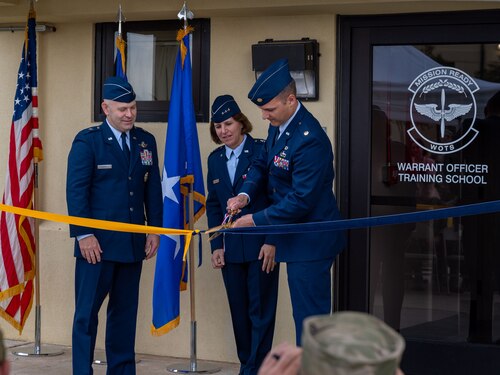 U.S. Air Force Brig. Gen. Joseph Sheffield, Commander of the Jeanne M. Holm Center, U.S. Air Force Lt. Gen. Andrea Tullos, Commander and President of Air University, and U.S. Air Force Maj. Nathaniel Roesler, Warrant Officer Training School commandant, cut the ceremonial ribbon at the WOTS ribbon cutting ceremony at Maxwell Air Force Base, Alabama, Sept. 25, 2024. (U.S. Air Force photo by Senior Airman Evan Lichtenhan)
