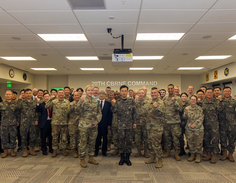 Dozens of U.S. and South Korean service members stand for a photo in a room.