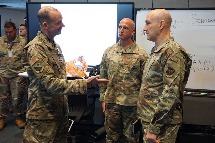 uniformed Chief of Staff of the Air Force Gen. David Allvin and Chief Master Sgt. of the Air Force Chief David Flosi listen to Maj. Gen. Christopher Niemi discuss Bamboo Eagle 24-3's operational-level of war elements.