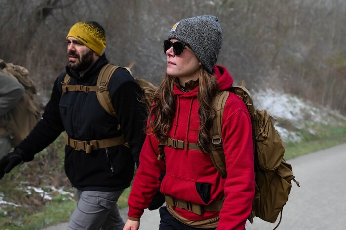 Tech. Sgt. Shelley Rozich and her husband, Jordan, march toward the left frame