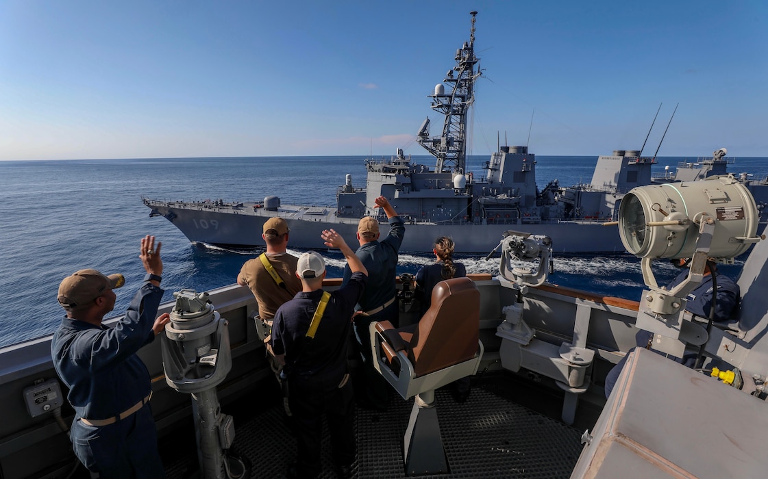 Sailors aboard USS Dewey (DDG 105) wave to the JMSDF destroyer JS Ariake (DD 109) in the Timor Sea.