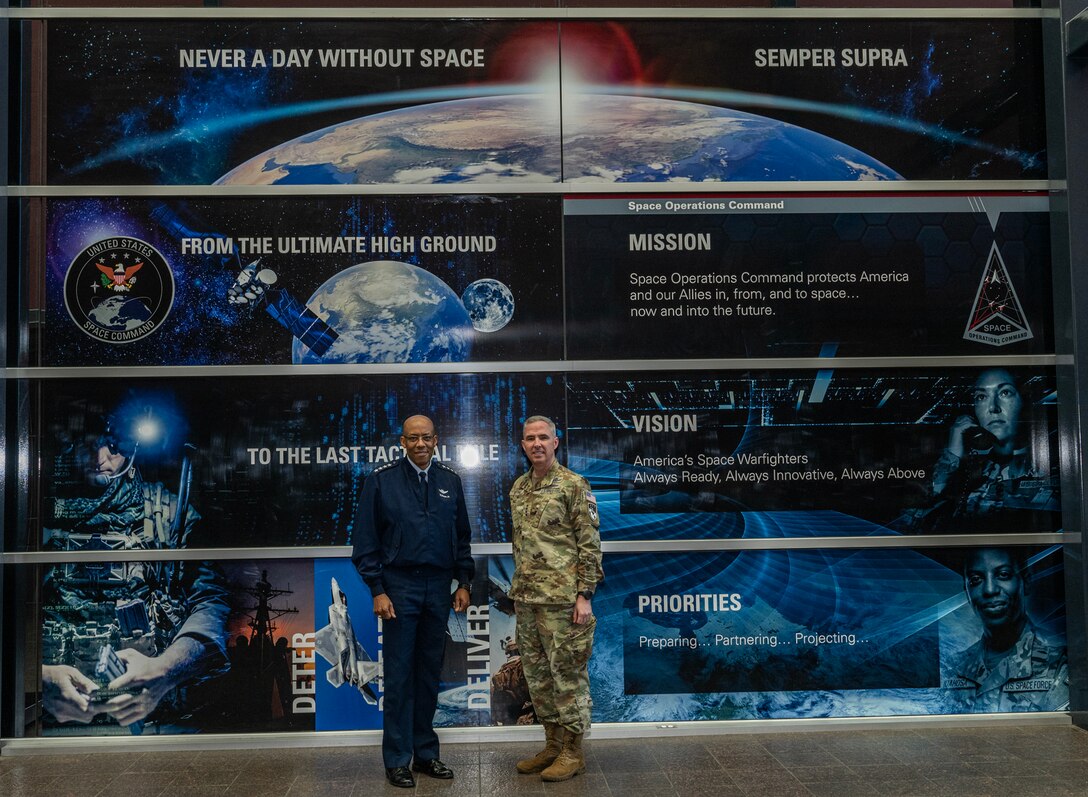Two service members in uniform stand together.