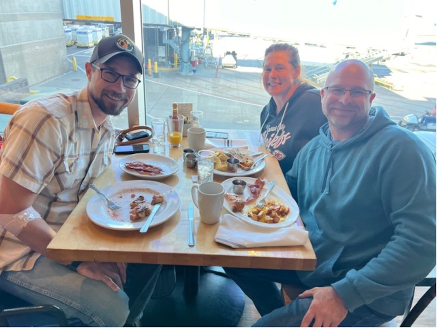 From left, Ben Wagner, a U.S. Forest Service assistant fire management officer, Maj. Alana Taylor, a nurse practitioner with the 139th Medical Group, Missouri Air National Guard, and Jeff Taylor, Alana’s husband and a firefighter paramedic, share breakfast at an airport in Denver Sept. 2, 2024. Wagner was suffering from severe dehydration and exhaustion midflight when the Taylors stepped in to assist.