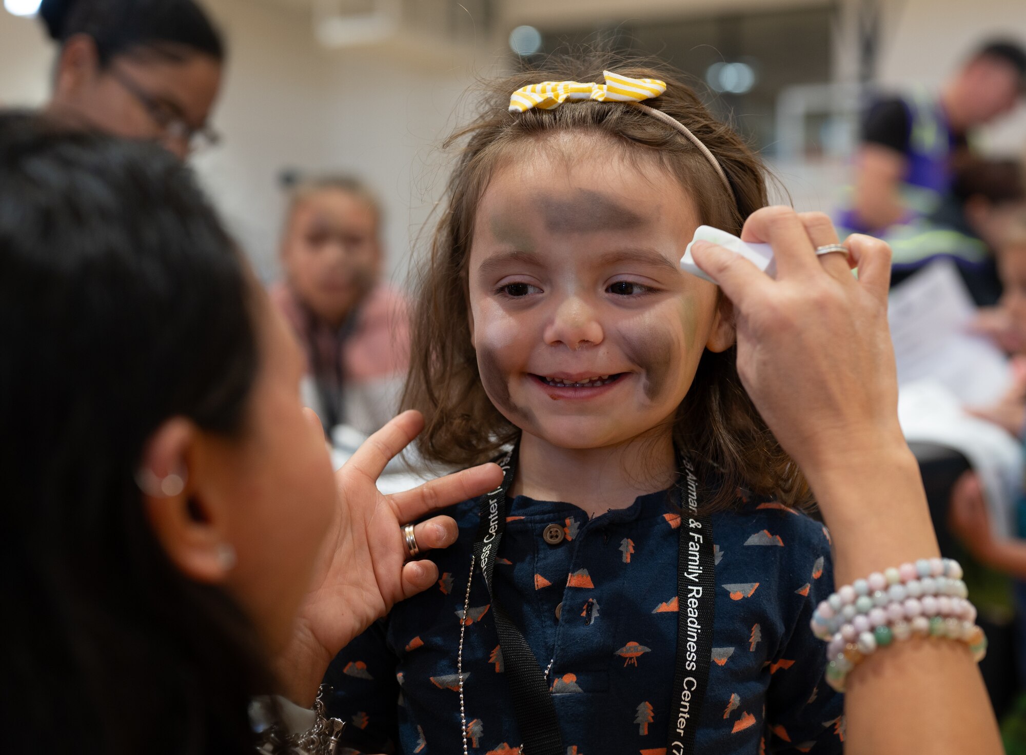 A volunteer is applying paint to a little child as part of the deployment processing line.