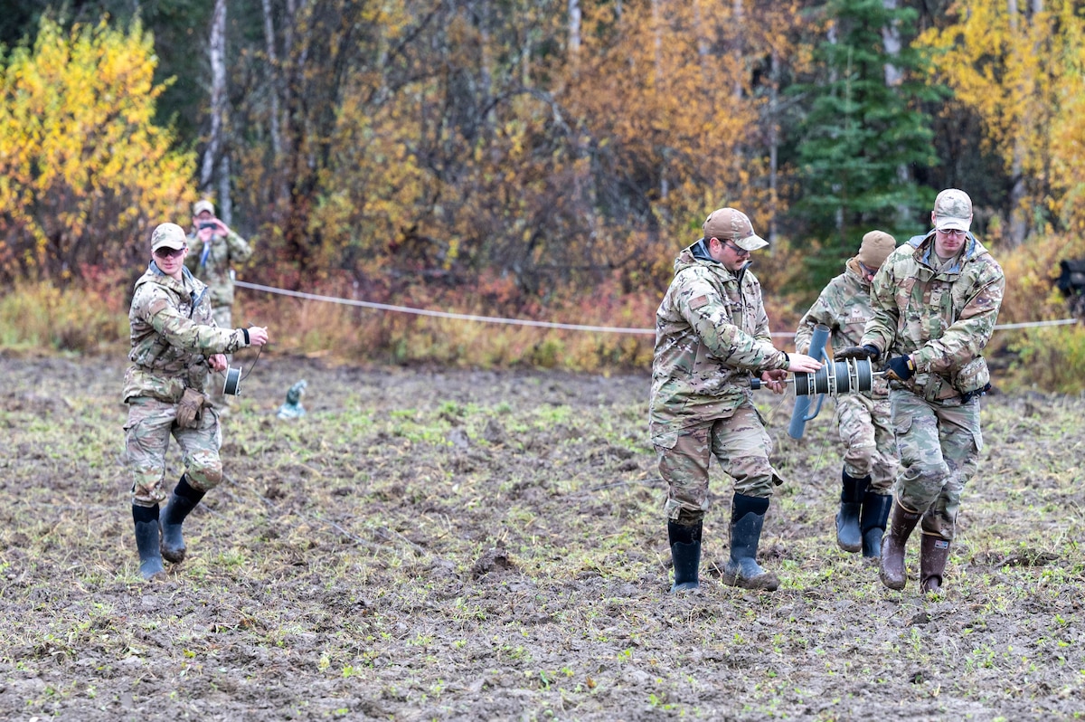 U.S. Air Force Airmen, assigned to the 354th Civil Engineering Squadron explosive ordnance disposal flight, unravel multiple spools of detonating cord at Eielson Air Force Base, Alaska, Sept. 20, 2024.