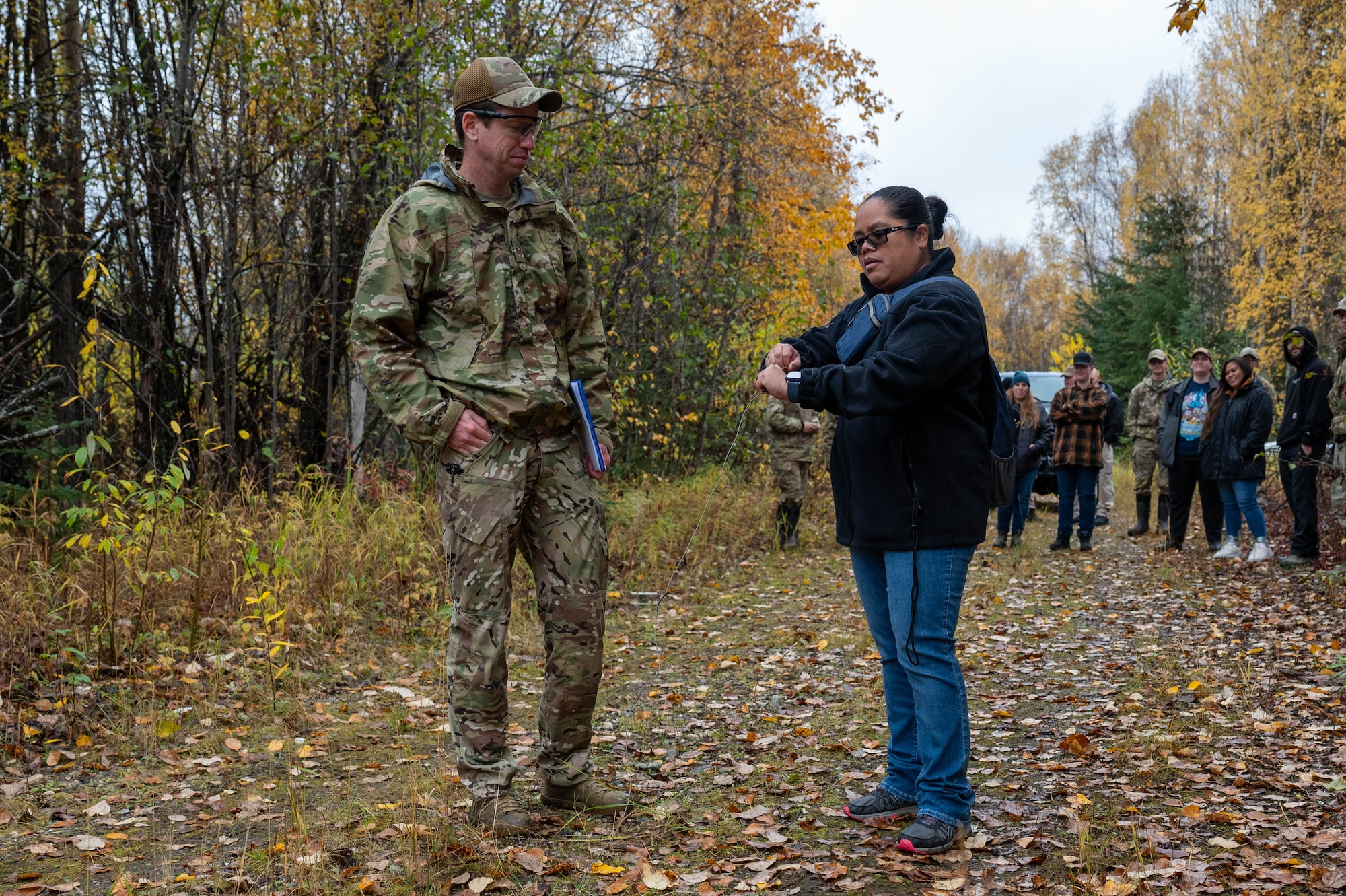 U.S. Air Force Tech. Sgt. Adam Ray, 354th Civil Engineering Squadron explosive ordnance disposal logistics section chief, left, observes Benita Hair, Transportation Security Administration Fairbanks transportation security manager, pulling the pin on a detonation cord at Eielson Air Force Base, Alaska, Sept. 20, 2024.