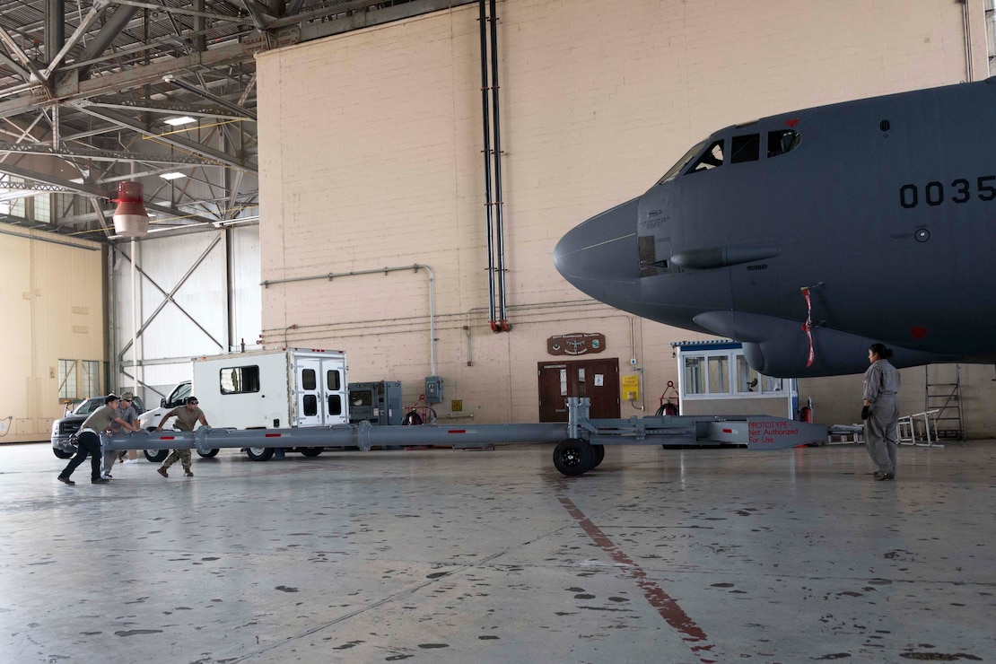 U.S. Airmen, assigned to the 2nd Maintenance Squadron, roll a B-52 Stratofortress towbar prototype into position during a demonstration at Barksdale Air Force Base, Louisiana, Sept. 10, 2024. The demonstration included assembly, transport and towing capabilities of the new prototype. If adopted, the new towbar could reduce readiness and mobility requirement problems inherent in current Agile Combat Employment efforts. (U.S. Air Force photo by Senior Master Sgt. Ted Daigle)