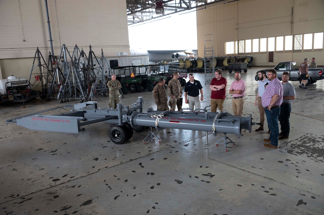 U.S. Airmen, Air Force Global Strike Command officials, and visitors from Louisiana Tech University gather around a new B-52 Stratofortress towbar prototype prior to a demonstration of its capabilities at Barksdale Air Force Base, Louisiana, Sept. 10, 2024. The prototype, an AFGSC initiative, was designed in a collaboration between Louisiana Tech engineering students, and AFGSC’s innovation arm called STRIKEWERX. (U.S. Air Force photo by Senior Master Sgt. Ted Daigle)