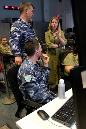 Royal Australian Air Force and U.S. civilian talk on operations floor