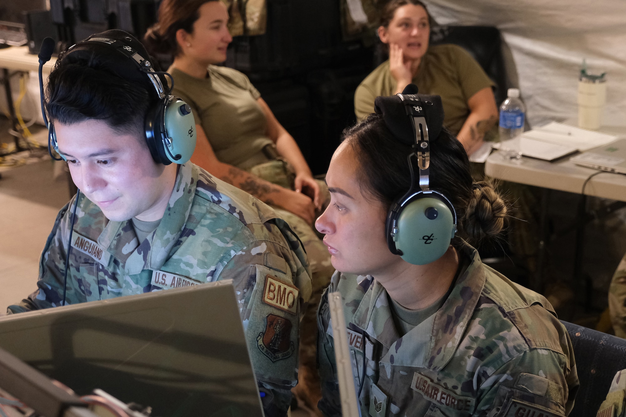 US Air Force Aimen wearing headphones work on computers