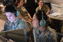 US Air Force Aimen wearing headphones work on computers
