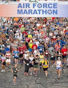 A high-angle photo of a large group of runners underneath a sign that reads "Air Force Marathon".