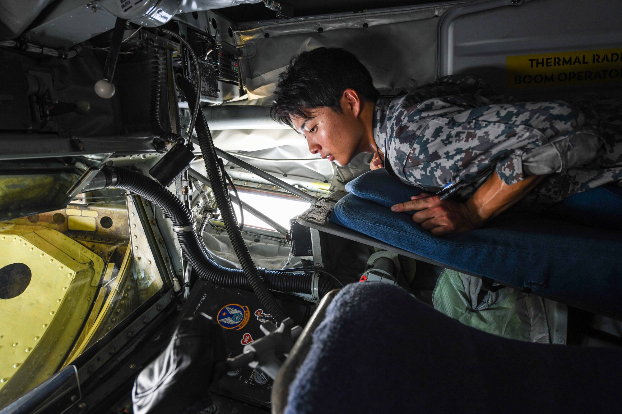 Japan Air Self-Defense Force Airman 1st Class Takumi Taniwaki, Naha Air Rescue Squadron flight equipment technician, examines a U.S. Air Force KC-135 Stratotanker boom pod during a base tour hosted by the 18th Maintenance Group at Kadena Air Base, Japan, Sept. 12, 2024. The tour allowed JASDF airmen to learn about 18th MXG operations and capabilities, increasing interoperability of U.S. and Japanese forces. (U.S. Air Force photo by Airman 1st Class Jonathan R. Sifuentes)