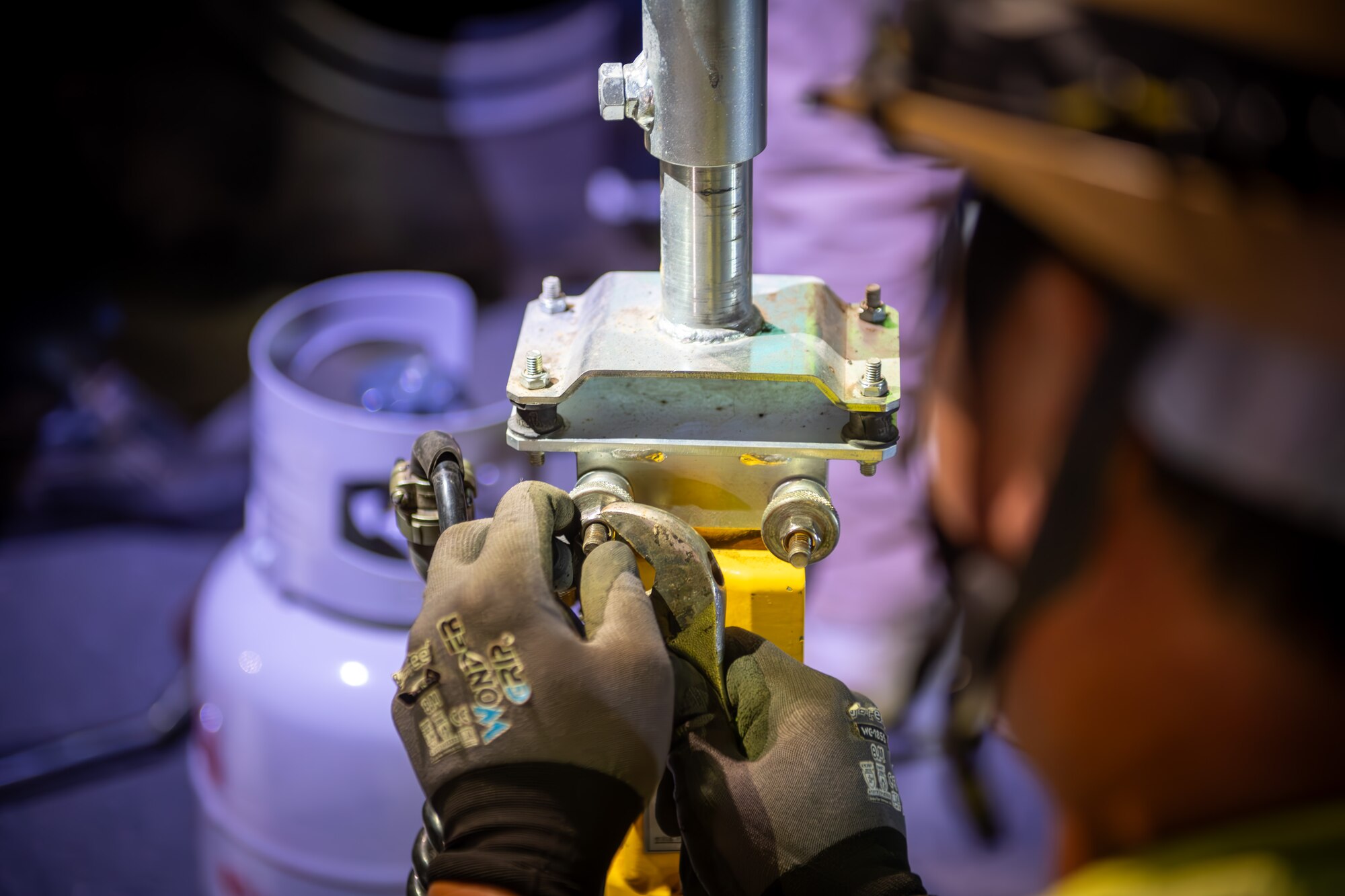 A CES members uses a wrench to tighten a bolt.