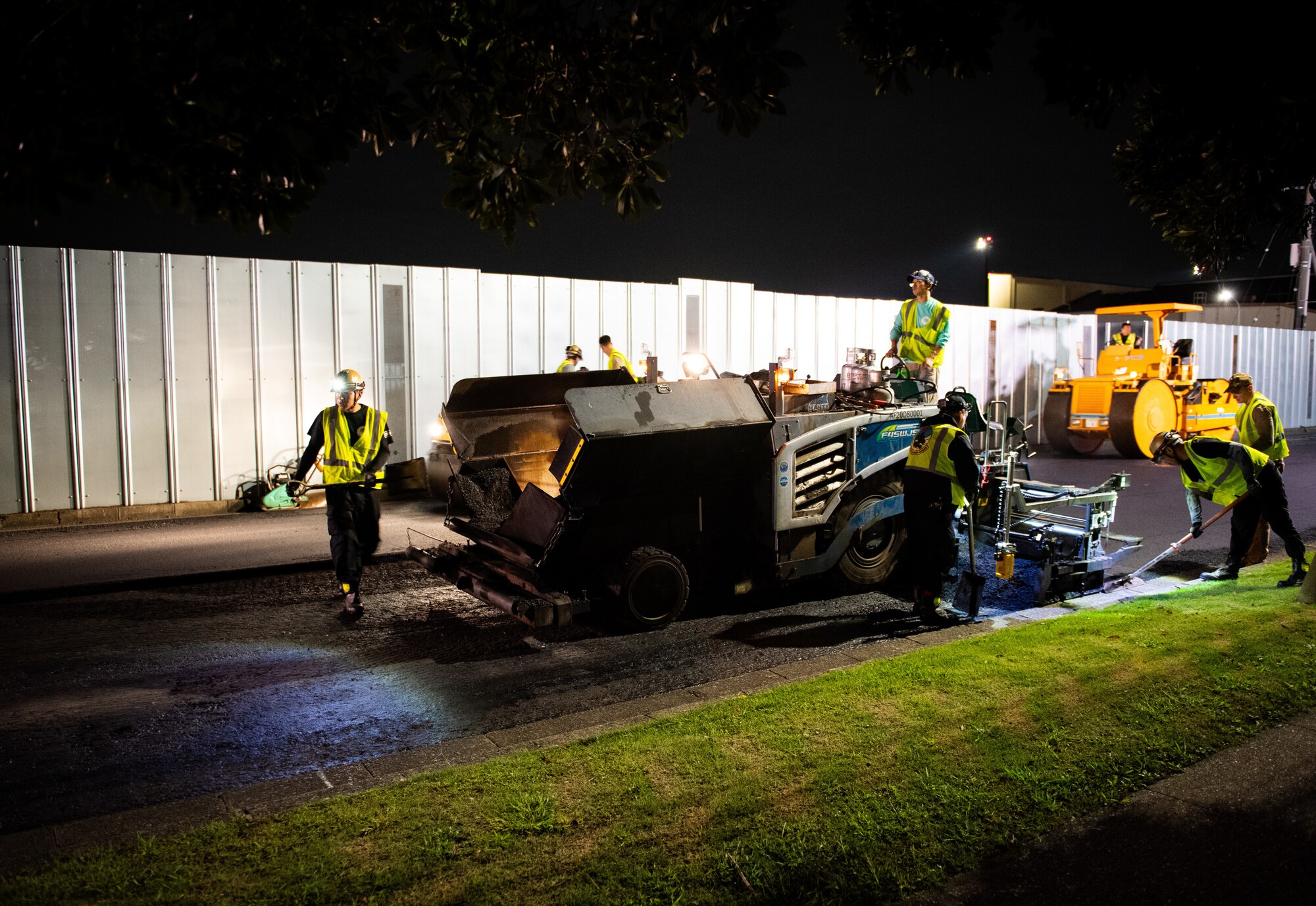 CES members work around the asphalt paver.