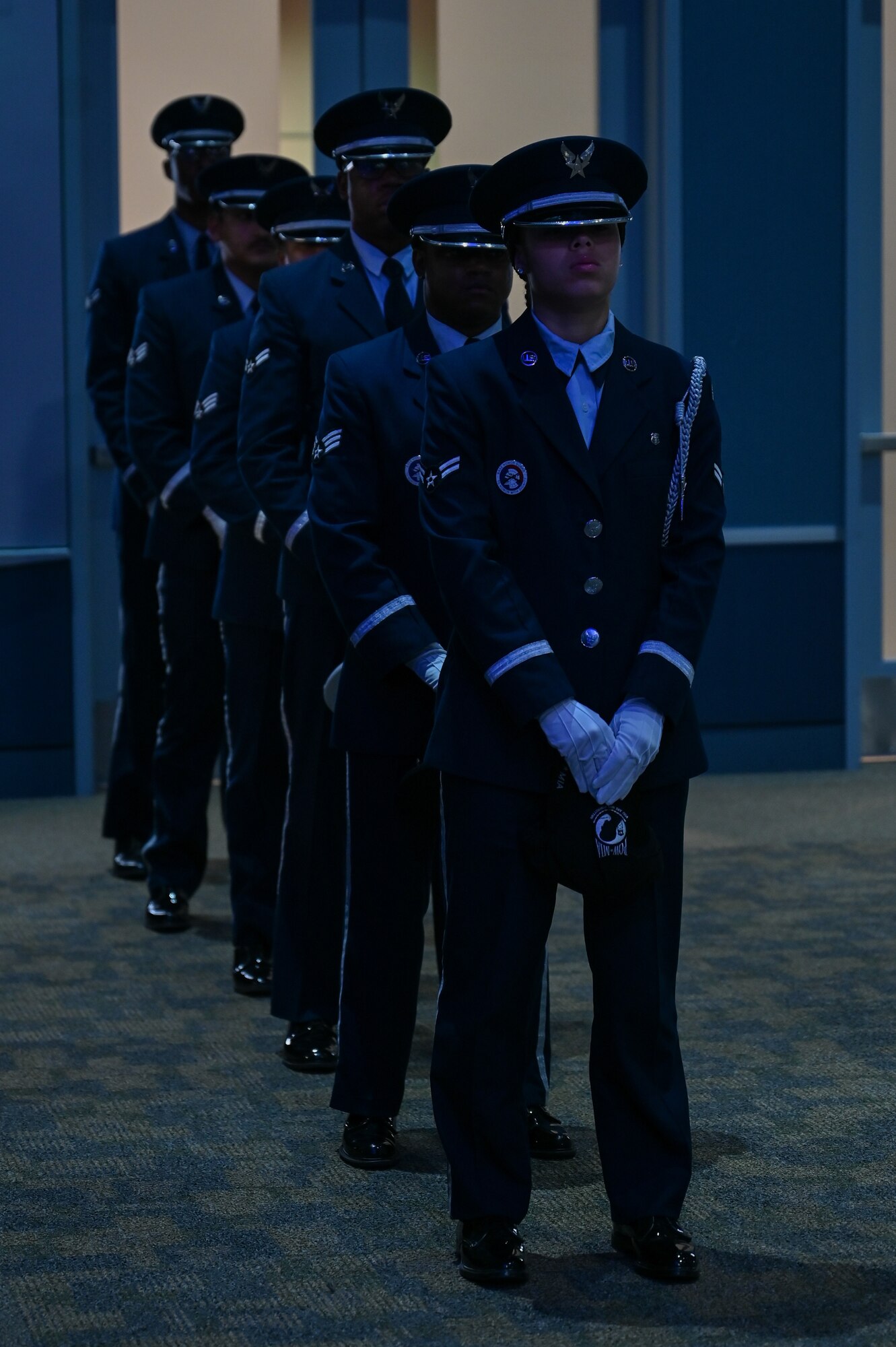 Members from the base Honor Guard stand in a line waiting on their cue to perform their ceremony.