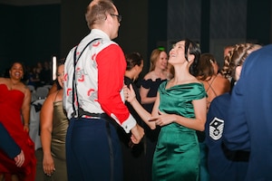 Airman and his wife dancing on the dance floor in between other dancing participants.