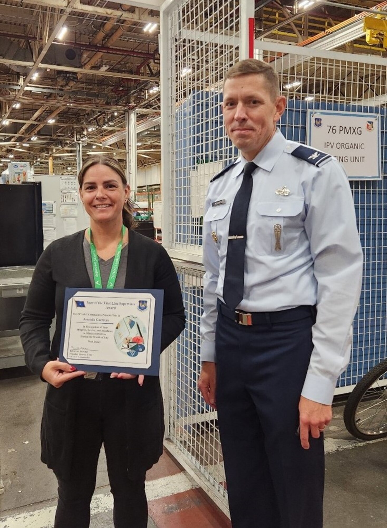 Man standing next to woman holding a certificate