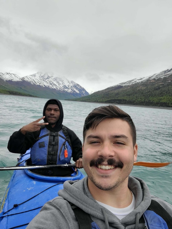 Two people pose for a portrait while kayaking.