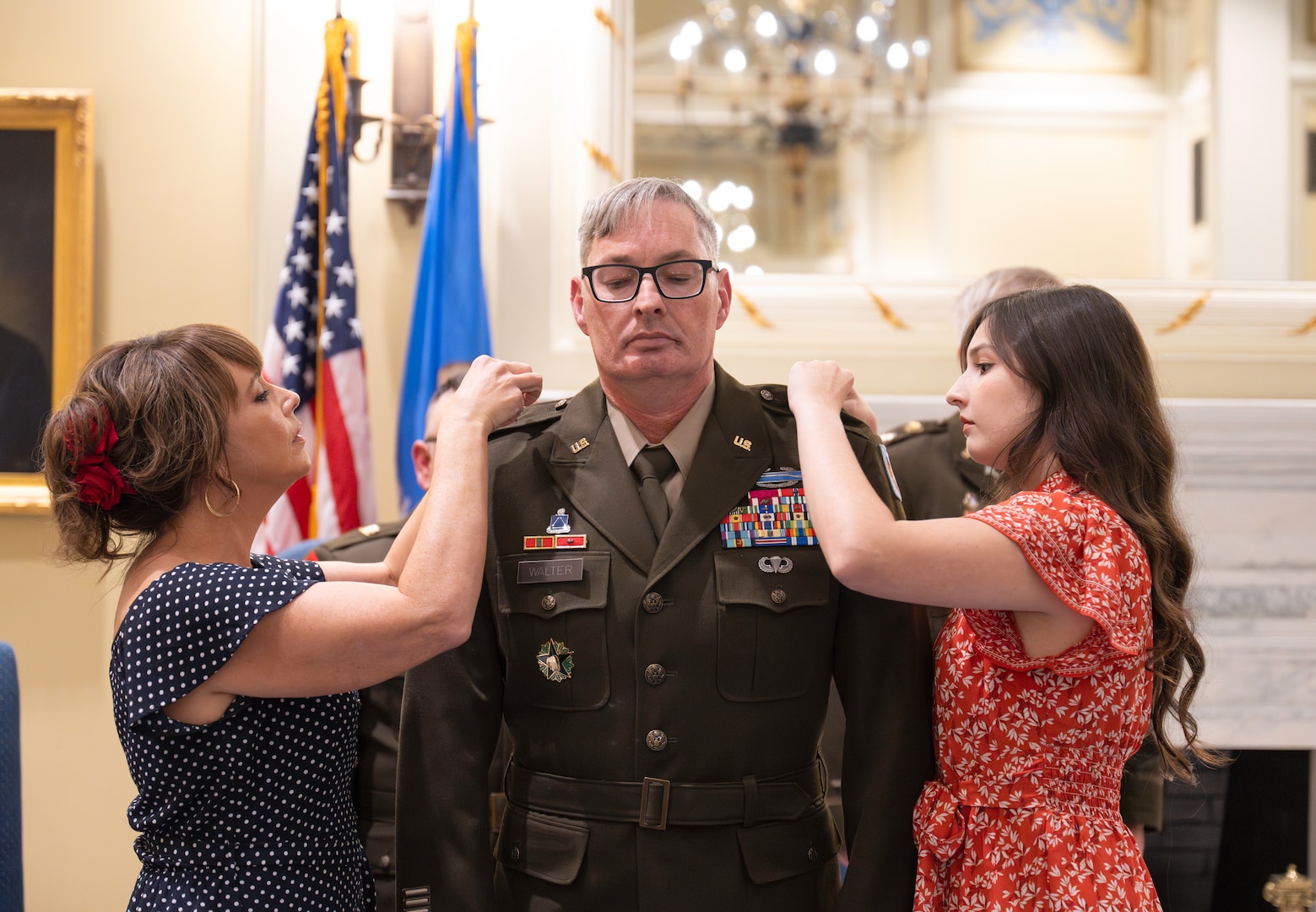 Brig. Gen. Robert Walter stands as his wife (left) and daughter (right) pin on his stars during his promotion ceremony in the Blue Room at the Oklahoma Capitol on Sept. 26, 2024. Walter serves as the assistant adjutant general - Army for Oklahoma and advises and assists the adjutant general in preparing Oklahoma Army National Guard units for domestic operations and mobilization. (Oklahoma National Guard photo by 1st Sgt. Mireille Merilice-Roberts)